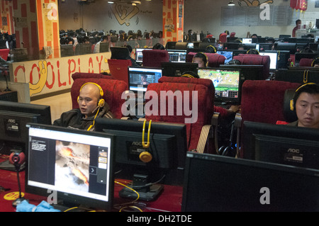 De jeunes Chinois, hommes et adolescents, s'assoient devant de grands écrans LCD d'ordinateur en utilisant des micro-casques et en jouant à des jeux en ligne et en suivant des flux en direct dans un Wangba(r), qui se traduit par un cybercafé à Beijing, en Chine. PRC. © Olli Geibel Banque D'Images