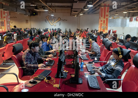 De jeunes Chinois, hommes et adolescents, s'assoient devant de grands écrans LCD d'ordinateur en utilisant des micro-casques et en jouant à des jeux en ligne et en suivant des flux en direct dans un Wangba(r), qui se traduit par un cybercafé à Beijing, en Chine. PRC. © Olli Geibel Banque D'Images