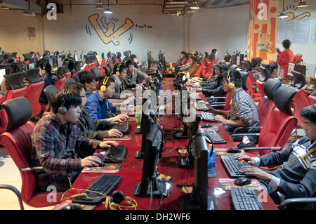 De jeunes Chinois, hommes et adolescents, s'assoient devant de grands écrans LCD d'ordinateur en utilisant des micro-casques et en jouant à des jeux en ligne et en suivant des flux en direct dans un Wangba(r), qui se traduit par un cybercafé à Beijing, en Chine. PRC. © Olli Geibel Banque D'Images