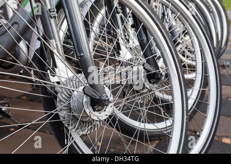 Gris moderne des vélos à louer dans une rangée sur un parking gratuit Banque D'Images