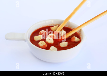 Croûtons et bâtonnets de pain de sauce rouge sur fond gris. Banque D'Images