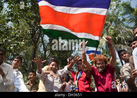 Les hommes de la danse en agitant le drapeau des partisans de la MNS célébrant la victoire électorale du candidat Parti politique MNS Mumbai Maharashtra Inde Asie Oct 2009 Banque D'Images