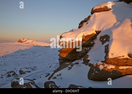 Un hiver enneigé juste avant le coucher du soleil, sur les sommets rocheux des landes ; dans le parc national de Dartmoor, Devon, dans le sud-ouest de l'Angleterre, en Grande-Bretagne. Banque D'Images