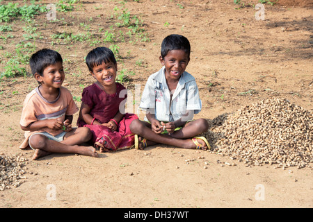 Les jeunes enfants du village Indien assis jambes croisées sur le terrain dans un village de l'Inde rurale. L'Andhra Pradesh, Inde Banque D'Images