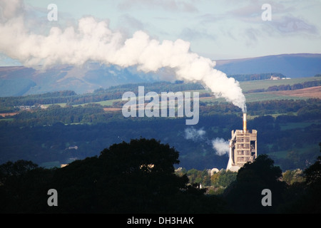 Une cheminée industrielle éructe de la vapeur dans une belle campagne. Banque D'Images