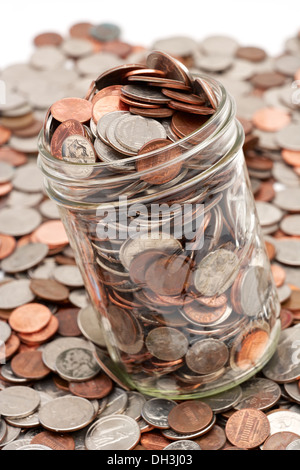 Pot mason de verre plein de changement de poche lâche tomber sur fond blanc Banque D'Images