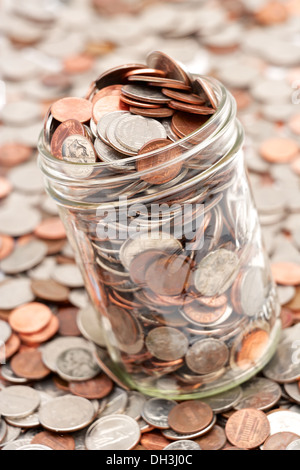 Pot mason de verre plein de changement de poche lâche tomber sur fond blanc Banque D'Images