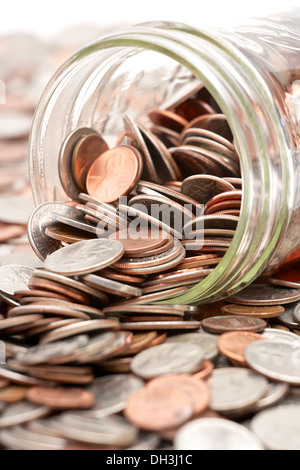 Pot mason de verre plein de changement de poche lâche tomber sur fond blanc Banque D'Images