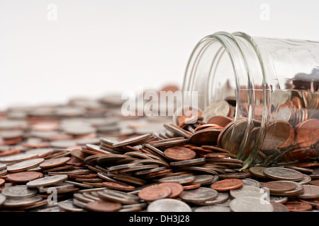 Pot mason de verre plein de changement de poche lâche tomber sur fond blanc Banque D'Images