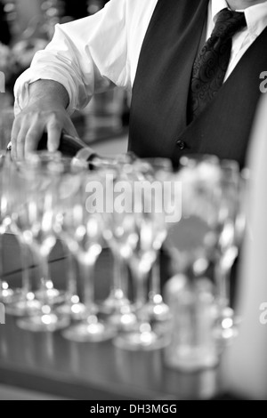 Waiter pouring champagne into champagne glasses Banque D'Images