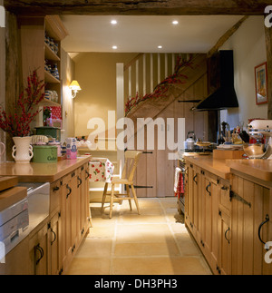 Pin simple portes avec poignées en fer forgé sur les placards en chalet cuisine avec escalier en bois Banque D'Images