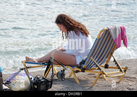 Femme assise dans un transat sur la mer Égée. L'île de Symi, Grèce Banque D'Images