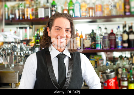 Jeune barman Barista ou debout dans son café ou bar Banque D'Images