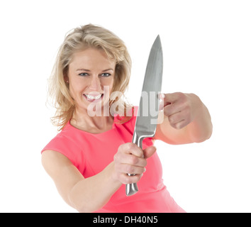 Femme avec lame de couteau à l'essai avec le doigt Banque D'Images