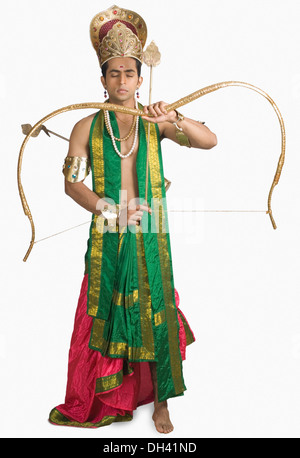 Jeune homme dans un caractère d'Arjuna et tenant un arc et une flèche Banque D'Images