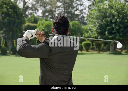 Businessman swinging a golf club Banque D'Images