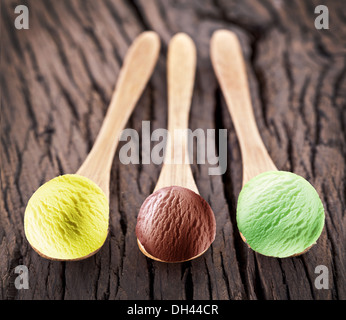 Boules de crème glacée dans les cuillères sur une table en bois. Banque D'Images