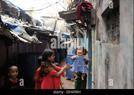 Enfants jouant à la poupée dans les bidonvilles de Mumbai Inde Asie Kamathipura Bachuwadi Banque D'Images