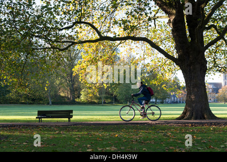 Un homme à vélo sur un sentier à Cambridge UK Vert Jésus sur un matin d'automne. Banque D'Images