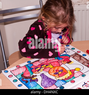 Petite fille en coloriant un dessin dans un livre de coloriage Banque D'Images