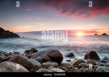 Le soleil se couche sur Porth Nanven Cove près de Penzance en Cornouailles, également connu sous le nom de vallée de la COT Banque D'Images