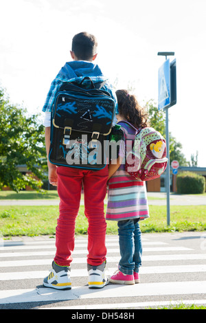 Enfants traversant un passage clouté Banque D'Images