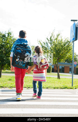 Enfants traversant un passage clouté Banque D'Images