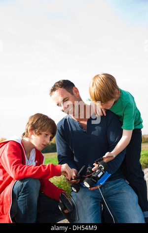 Père bricoler sur un modèle de voiture télécommandée avec ses fils Banque D'Images