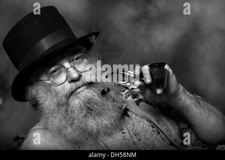 Un homme âgé avec une longue barbe et vêtu d'un haut chapeau et lunettes, fumant une pipe, Reith im Alpbachtal, district de Kufstein, Tyrol du Nord Banque D'Images