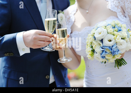 Mariée et le marié faire un toast avec verres de champagne après la cérémonie du mariage Banque D'Images