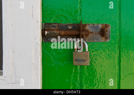 Serrure rouillée et d'un cadenas sur une porte vert vif Banque D'Images