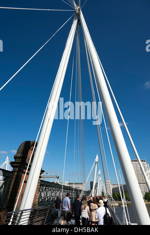 Personnes traversant la Tamise sur l'un des Golden Jubilee Bridges , London, England, UK Banque D'Images