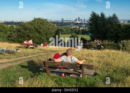 Jeune couple profitant de la vue depuis un banc sur la Colline du Parlement, Hampstead Heath, London, England, UK Banque D'Images