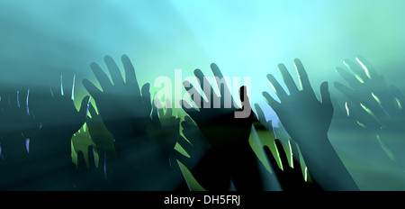 Une foule de mains levées d'affichage au niveau de la foule spectateur entrecoupées de spots colorés et une atmosphère de Smokey Banque D'Images