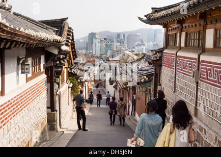 La juxtaposition de l'architecture. Vieilles maisons Coréennes traditionnelles dans le village de Bukchon Hanok et bâtiments modernes à l'arrière-plan. Banque D'Images