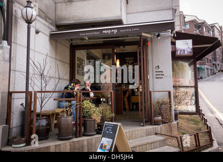 Les touristes européens de prendre un verre dans un café dans le village de Bukchon Hanok, Séoul, Corée Banque D'Images