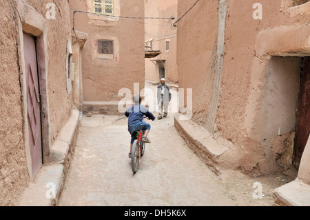 Garçon avec vélo et un vieil homme, l'architecture de pisé de terre dans la vieille ville ou Médina, Ouarzazate, Maroc, Afrique Banque D'Images