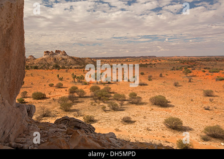 Castle Rock et Chambers pilier dans Australian Outback paysage avec de vastes plaines rouge s'étendant jusqu'à horizon lointain NT Banque D'Images