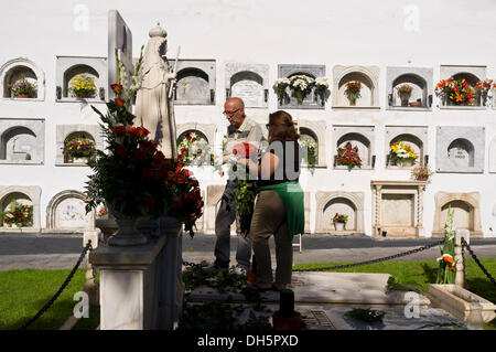 Tenerife, Canaries, Espagne. 06Th Nov, 2013. Fête des morts, Dia de los muertos, toutes les âmes 24. La famille visiter la tombe de leurs défunts membres de la famille et les décorer avec des fleurs en souvenir. Cimetière Municipal de Guia de Isora, Tenerife, Canaries, Espagne. Credit : Phil Crean A/Alamy Live News Banque D'Images