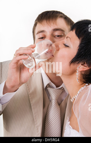 Le marié et la mariée boire de l'eau. White isolés. Banque D'Images