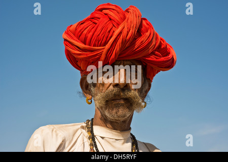 L'homme indien avec un turban rouge et boucles d'oreilles, portrait, Pushkar, Rajasthan, India Banque D'Images