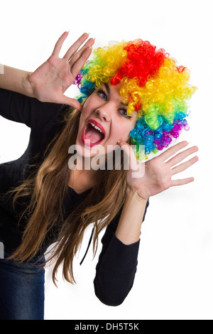 Sur la tête de la cheerful girl perruque multicolore. Isolé sur blanc. Banque D'Images