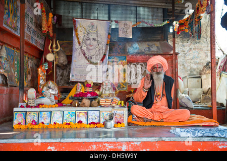 Sadhu, un saint homme ou ascétique errant assis dans la position du lotus sur une natte dans une prière hindoue de culte, Pushkar, Rajasthan Banque D'Images