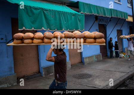 Un travailleur s'élèvent les plateaux de Pan de Muerto un pain doux spécial pour célébrer le Jour de la fête des morts connus en espagnol comme d'un de muertos au Marché Central de Abastos, 31 octobre 2013 à Oaxaca, au Mexique. Banque D'Images