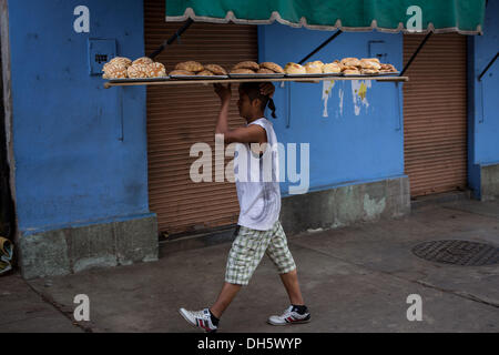 Un travailleur s'élèvent les plateaux de Pan de Muerto un pain doux spécial pour célébrer le Jour de la fête des morts connus en espagnol comme d'un de muertos au Marché Central de Abastos, 31 octobre 2013 à Oaxaca, au Mexique. Banque D'Images