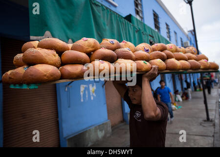 Un travailleur s'élèvent les plateaux de Pan de Muerto un pain doux spécial pour célébrer le Jour de la fête des morts connus en espagnol comme d'un de muertos au Marché Central de Abastos, 31 octobre 2013 à Oaxaca, au Mexique. Banque D'Images