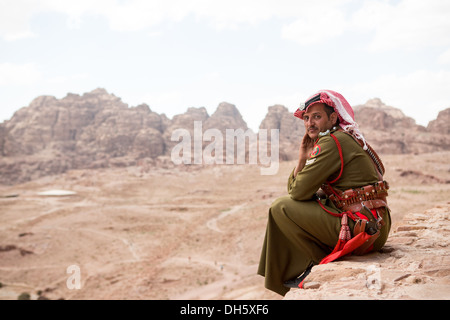 Soldat de la patrouille dans le désert jordanien donnant sur un point élevé de Petra Banque D'Images