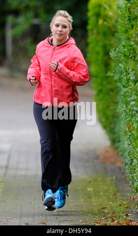 Young woman jogging et portant une veste coupe vent en automne