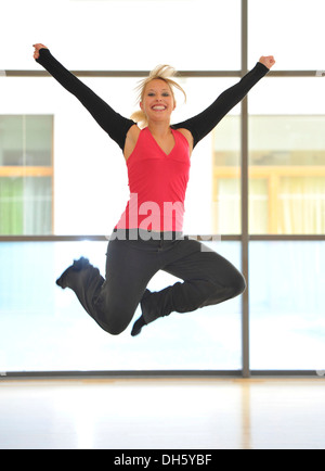 Jeune femme dansant, sautant en l'air, image symbolique de la vitalité, Haus des Sports, Maison du Sport, Sport, Stuttgart Banque D'Images