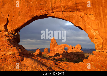 Tôt le matin, à l'humeur de passage de tourelle vue à travers la fenêtre du Nord, Windows Section, Arches National Park, Moab, Utah Banque D'Images